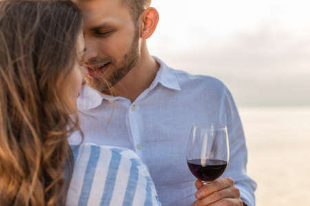 selective focus of bearded man looking at girlfriend and holding glass with red wineの写真素材
