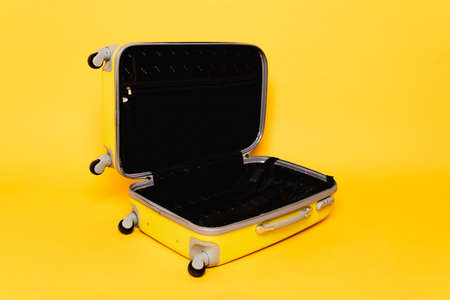 open empty travel bag on yellow background