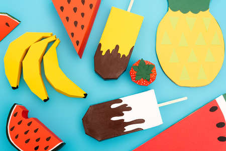 top view of paper summer fruits and ice cream on blue background