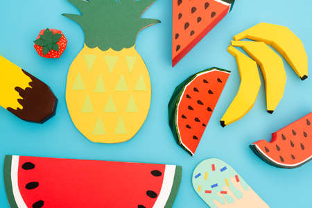 top view of paper summer fruits and ice cream on blue background