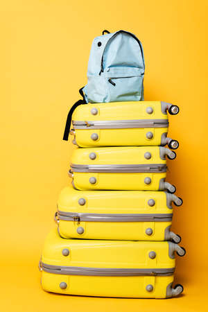 blue backpack on travel bags on yellow backgroundの写真素材