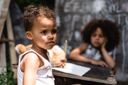 selective focus of poor african american child near curly sisterの写真素材
