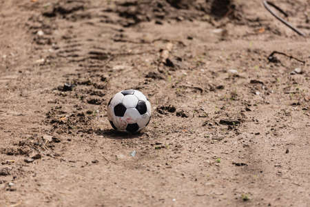 Dirty soccer ball on road on urban streetの写真素材