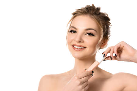 smiling naked beautiful blonde woman with makeup and black nails holding beige lip gloss isolated on...