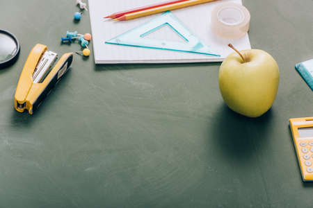 ripe apple, copy book and school supplies on green chalkboardの写真素材