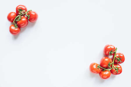 top view of red ripe fresh tomatoes on branches on white backgroundの写真素材