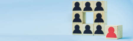 square of wooden blocks with black human icons and red piece on blue background, selective focus,...