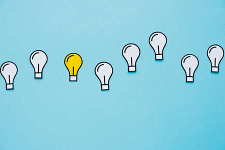 top view of paper light bulbs on blue background, business concept