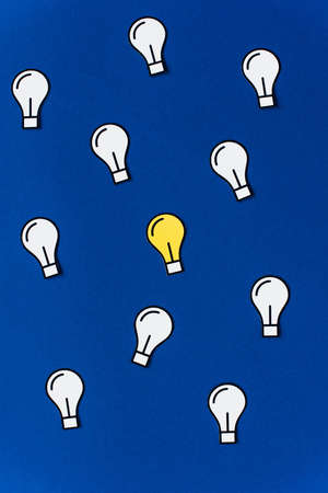 top view of paper light bulbs on blue background, business concept