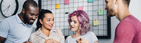 Panoramic crop of young multiethnic business people working in office