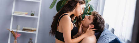 website header of woman touching muscular man in bedroom