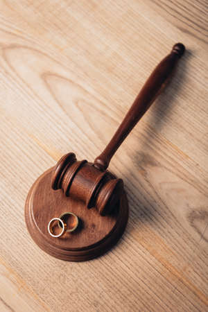 top view of golden rings on wooden gavel, divorce conceptの写真素材