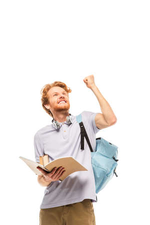 Student holding notebook and showing yeah gesture isolated on whiteの写真素材