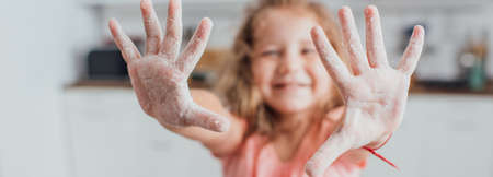 selective focus of child showing outstretched hands in flour, panoramic conceptの写真素材