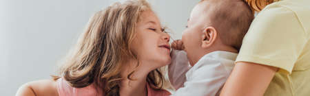 cropped view of mother holding son near daughter leaning to him, horizontal imageの写真素材