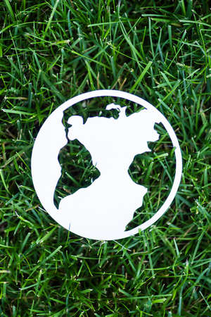 Top view of paper planet sign on green grass, ecology conceptの写真素材