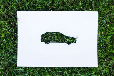 Top view of paper with car sign on green grass, ecology conceptの写真素材