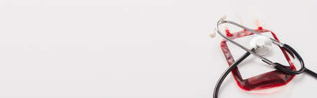 blood donation package with blank label and stethoscope on white, panoramic shotの写真素材