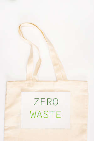 Top view of card with zero waste on bag on white background, ecology conceptの写真素材