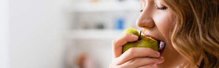 panoramic shot of woman with closed eyes eating appleの写真素材