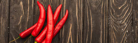 top view of chili peppers on wooden surface, panoramic shot