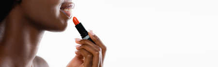 cropped view of african american naked woman applying lipstick isolated on white, panoramic shotの写真素材