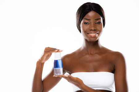 african american woman holding micellar water isolated on whiteの写真素材