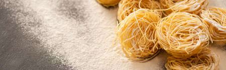 raw Italian Capellini with flour on black background, panoramic shotの写真素材