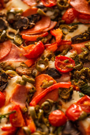 close up view of delicious Italian pizza with vegetables and salamiの写真素材