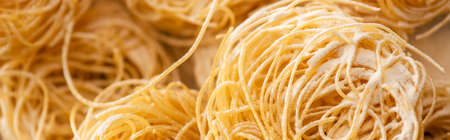 close up view of raw Italian Capellini with flour, panoramic shotの写真素材