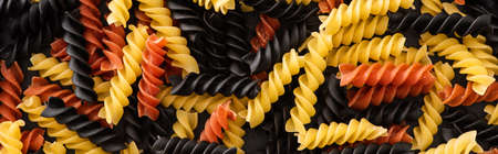 top view of raw colorful fusilli pasta, panoramic shotの写真素材
