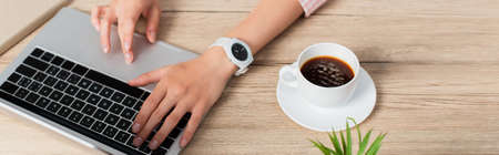 website header of freelancer using laptop near cup of coffeeの写真素材