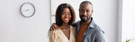 horizontal image of african american couple looking at camera while standing at home