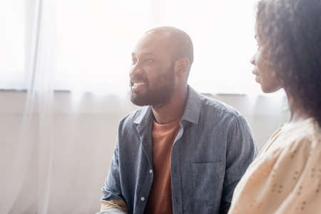 selective focus of african american wife looking at excited husband at home