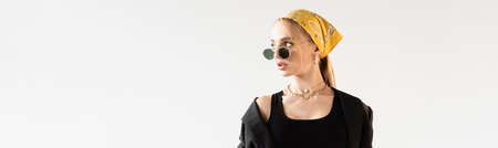 fashionable woman in sunglasses and yellow headscarf looking away isolated on white, panoramic shot