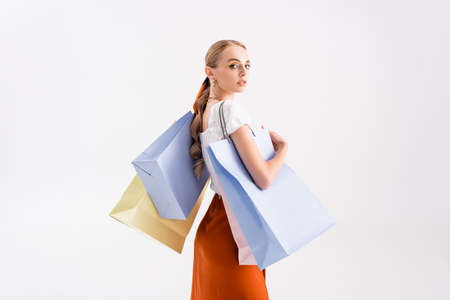 side view of elegant woman with shopping bags isolated on whiteの写真素材