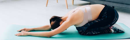Panoramic concept of sportswoman stretching during work out at home