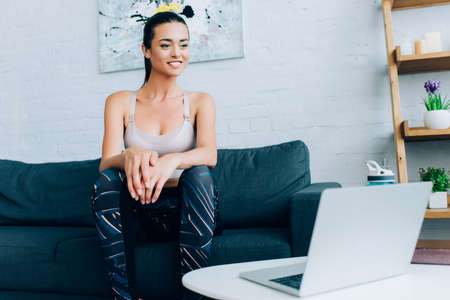 Selective focus of sportswoman looking at laptop during webinar at homeの写真素材