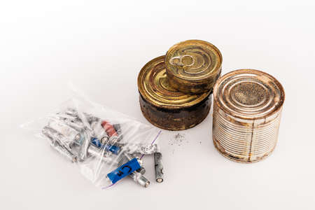 metal rusty tins and used batteries on white backgroundの写真素材