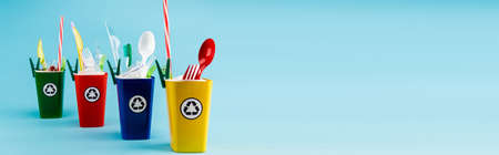 multicolored recycling bins with plastic on blue background, panoramic shotの写真素材
