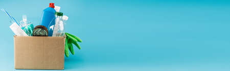 plastic rubbish and rubber gloves in cardboard box on blue background, panoramic shot