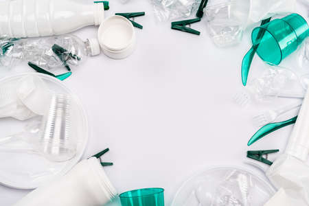 top view of plastic rubbish scattered on white background with copy spaceの写真素材
