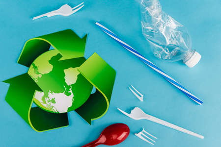 top view of recycling symbol near plastic rubbish on blue background