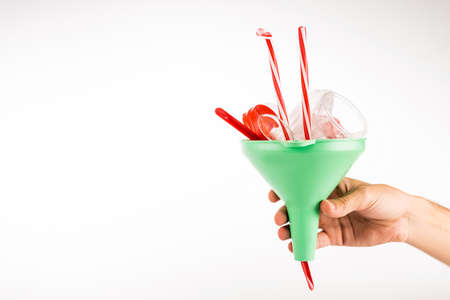 cropped view of man holding funnel with plastic objects on white background