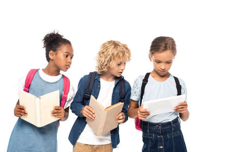 african american schoolgirl and blonde schoolboy with books looking at digital tablet in hands of...