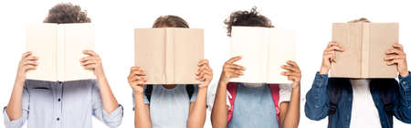 horizontal image of multicultural schoolgirls and schoolboys covering faces with books isolated on whiteの写真素材