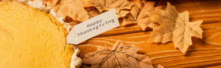 thanksgiving pumpkin pie with autumnal foliage on wooden background, panoramic shot