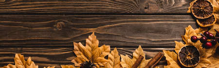 top view of autumnal decoration and foliage on brown wooden background, panoramic shot