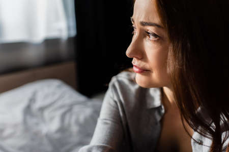 displeased brunette woman looking away at homeの写真素材