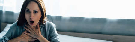 website header of frightened brunette woman touching throat while having panic attackの写真素材